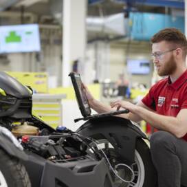Mitarbeiter mit Laptop am Fahrzeug