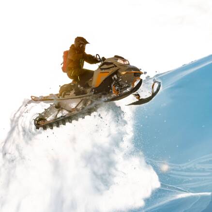 Eine Person fährt einen Ski Doo im Schnee