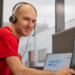 Mitarbeiter mit Headset vor Laptop